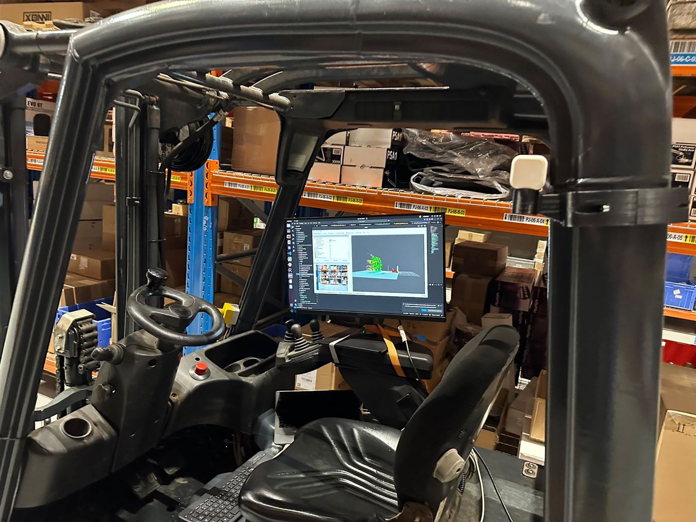 Bedieningsscherm van de retrofit in de cabine, met het magazijn op de achtergrond