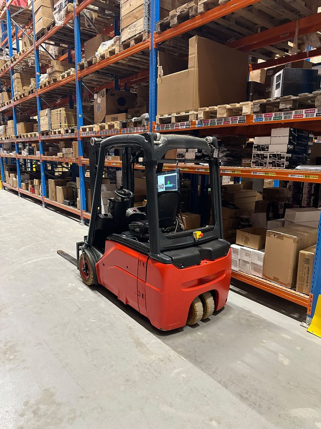 Autonome heftruck rijdt door een gang in het distributiecentrum